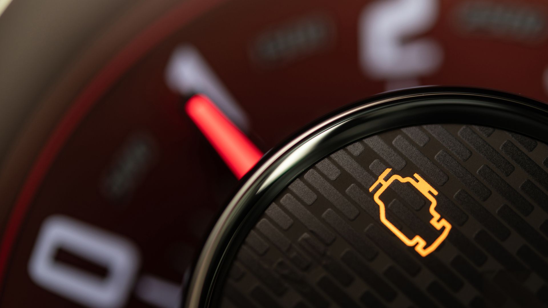 A close up of a speedometer with a red light