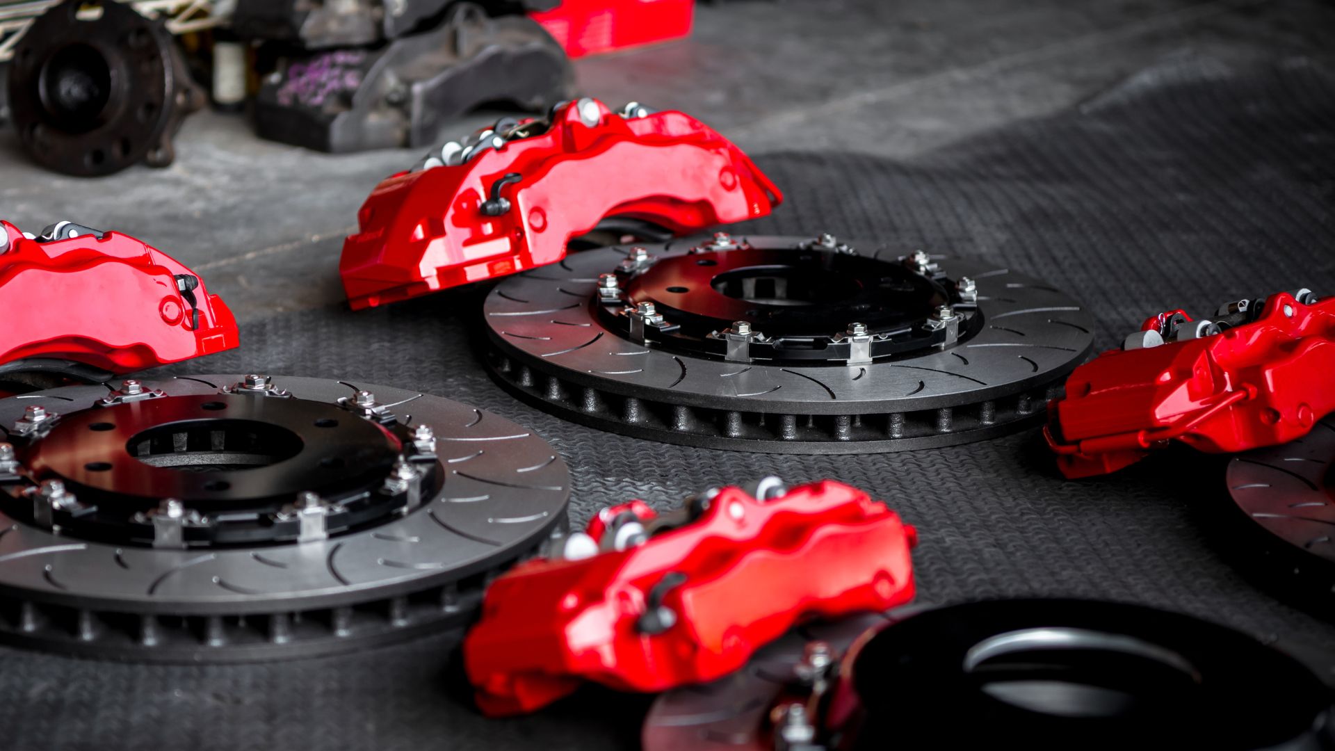 A group of red brake discs sitting on top of a floor